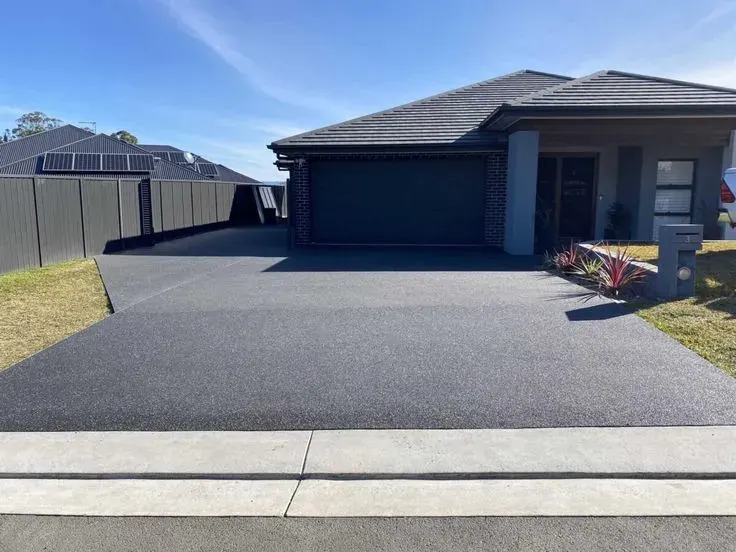 Professional concrete contractors in Seagoville TX showcasing expertly installed exposed aggregate driveway with seamless transitions and modern finish.